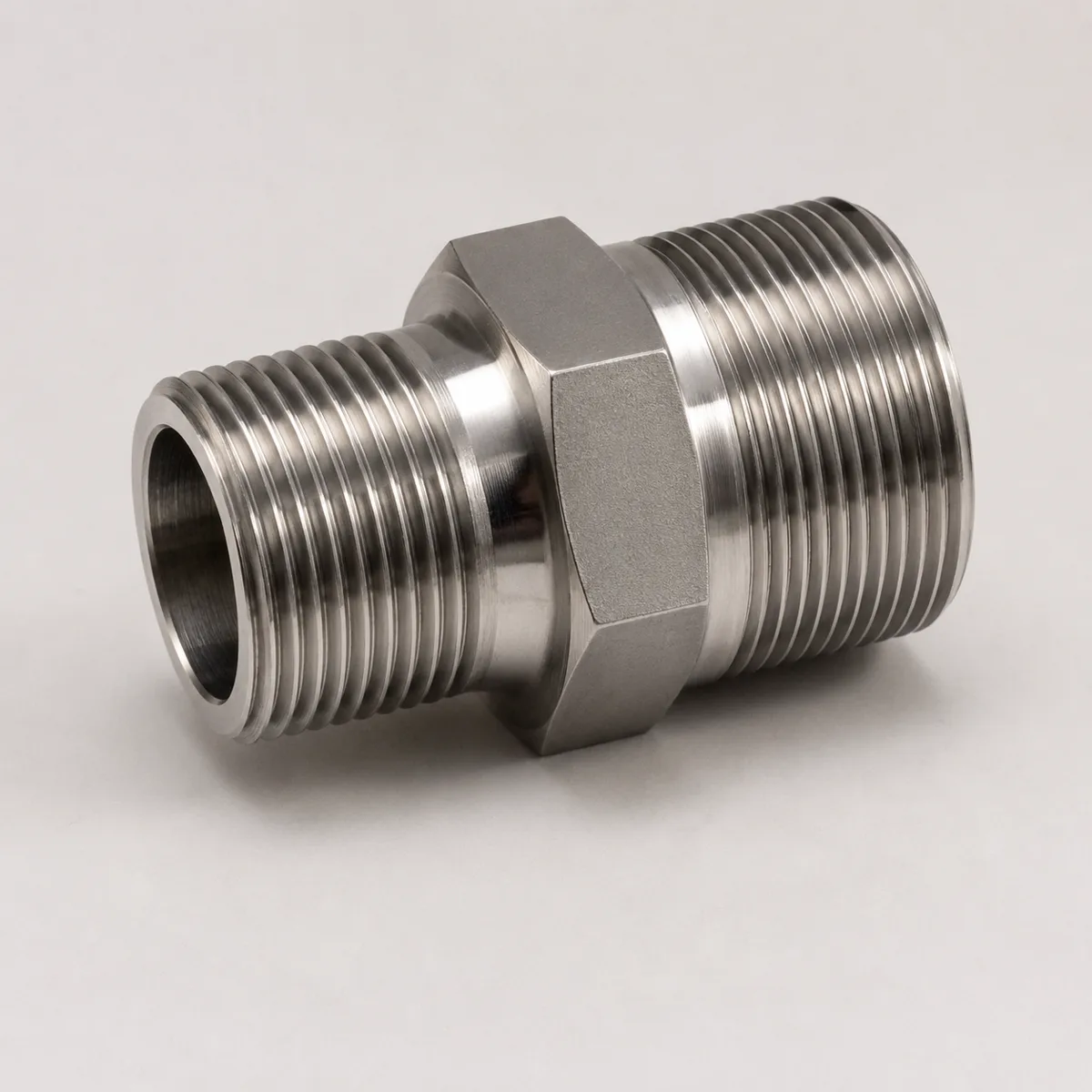 Stainless steel double-male reducing adapter with a hex drive band between a larger and a smaller male thread