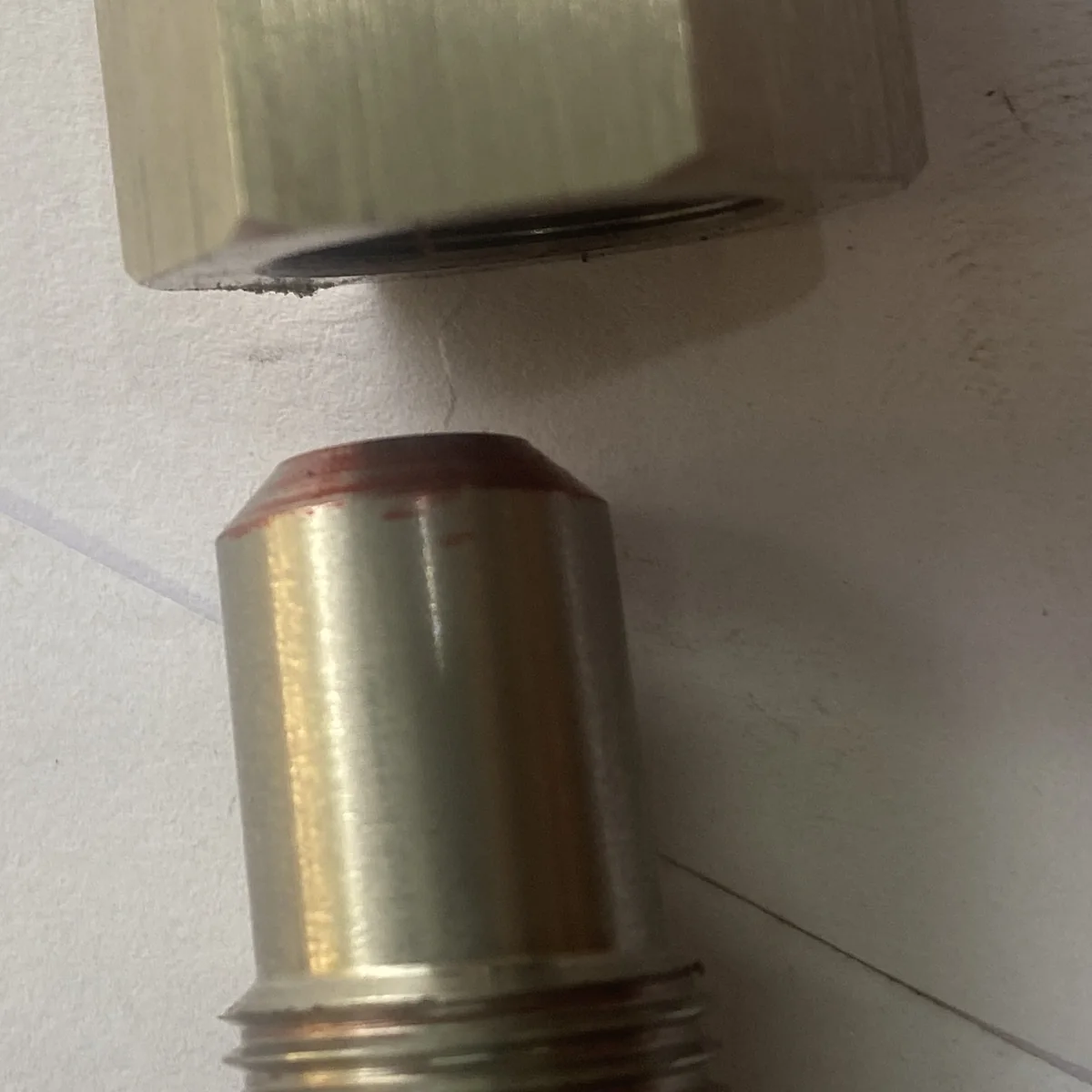 Close-up of the machined sealing land and lead-in chamfer on the male half of the 316 stainless assembly, red marking compound showing the contact band the seal runs on — EKINSUN