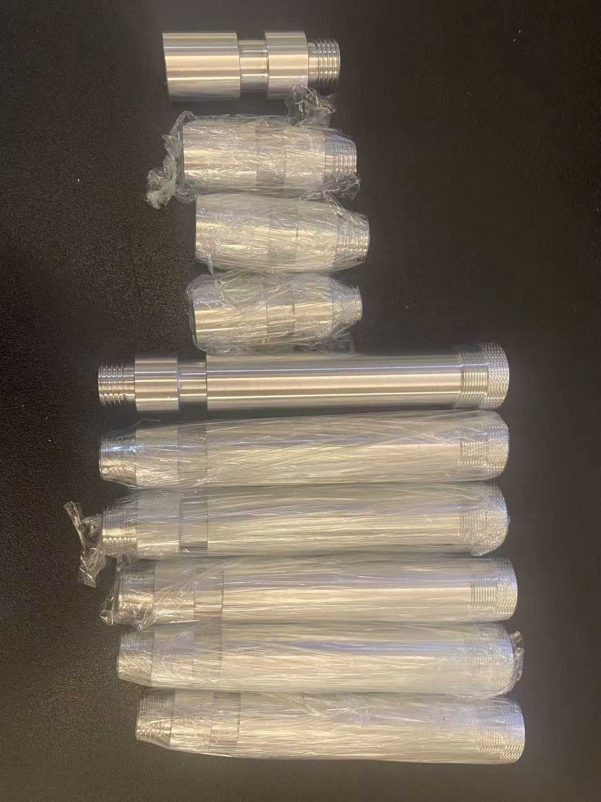 Batch of finished stainless steel multi-thread studs and couplers wrapped and ready for shipment
