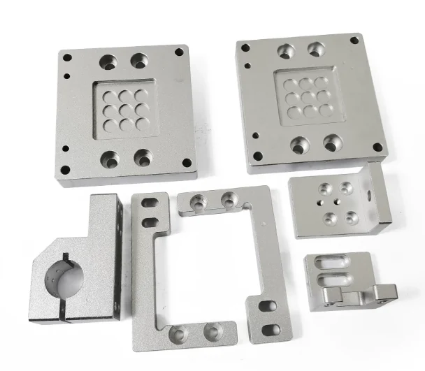 Two square aluminium plates with recessed pockets and locating arrays, an angle bracket with slotted holes, a spacer frame and a split shaft clamp block