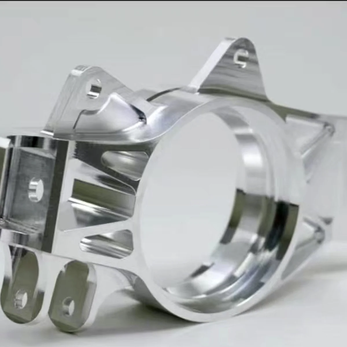 Precision aluminium motor clamp CNC machined with a concentric bore and clamp slot, polished to a mirror finish by EKINSUN