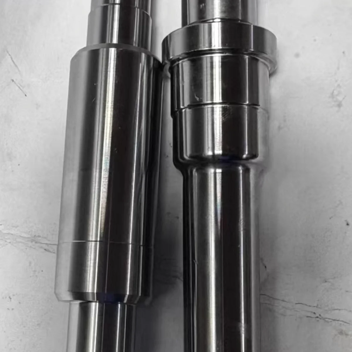 Pair of precision steel shafts with deep, straight central bored holes, gun-drilled and ground by EKINSUN