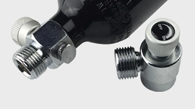 On/off adapter with a knob marked OFF and ON and a male side thread, beside the valve of a small black aluminium gas cylinder