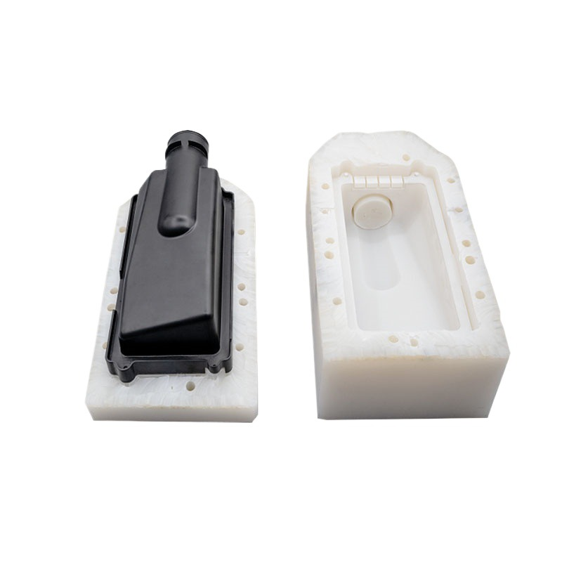 Two-part RTV silicone mold opened to show the black master part and the casting cavity — EKINSUN vacuum casting