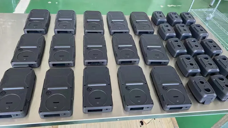 Rows of finished vacuum cast two-tone plastic enclosures on a workbench ready for assembly