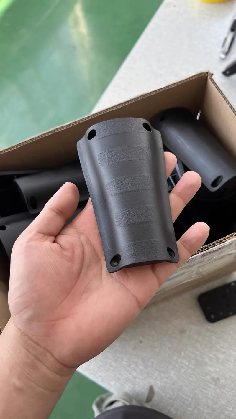 Cast plastic handle cover with leather-grain texture and metal inserts in the mounting holes, held in hand