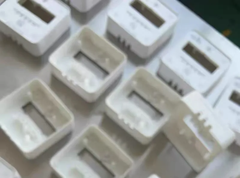 White cast housing shells straight from the silicone mold with flash still attached before trimming